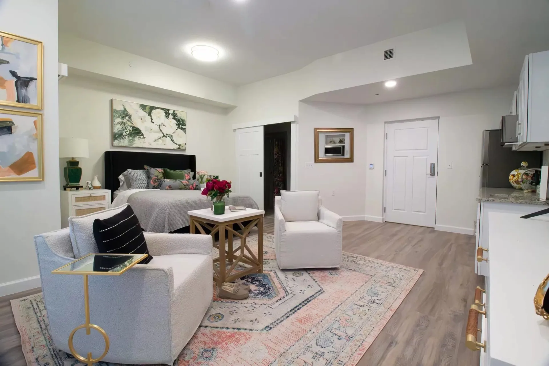 Furnished model residence with a living area and a bedroom beyond.