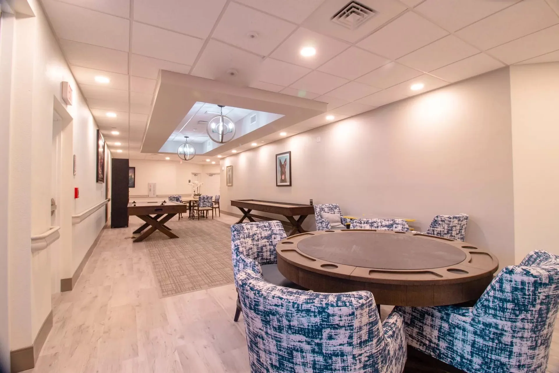 Recreation room with a pool table and card table under a ceiling with a recessed feature.